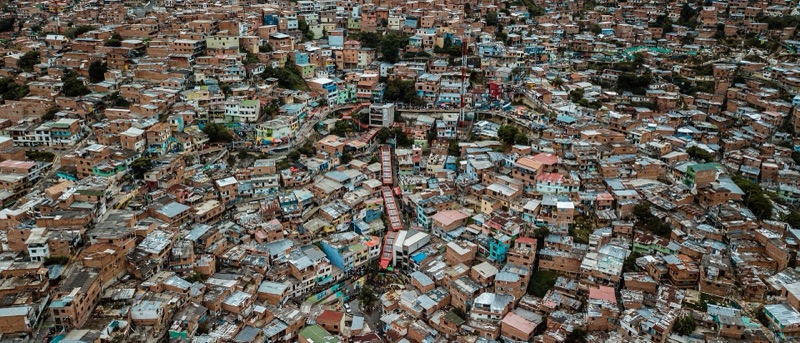 Aerial view of Comuna 13's hillside brick houses with the covered outdoor escalators climbing through the middle