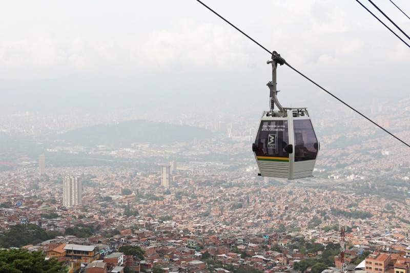 A Metrocable Line K cabin over hillside neighborhoods, with the Medellín valley spread out behind