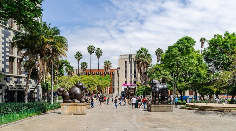 Bronze Botero sculptures of animals and figures on Plaza Botero, with the Museo de Antioquia behind the palm trees